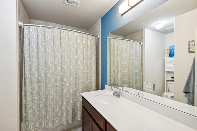 bathroom featuring walk in shower, vanity, and toilet