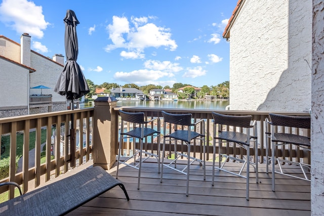 wooden terrace featuring a water view