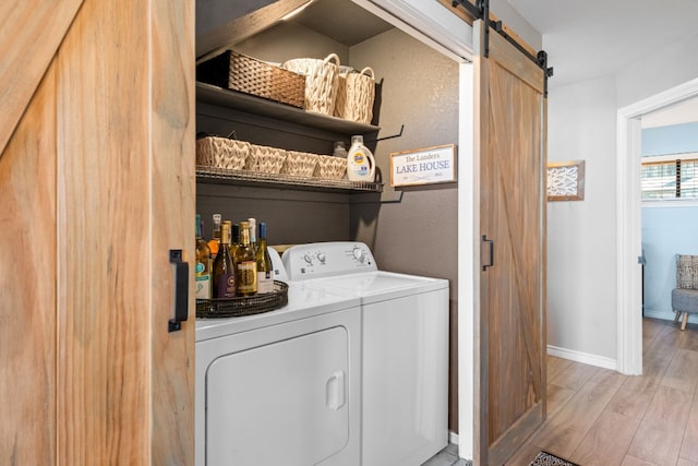 509 Short Circuit Unit 203, Horseshoe Bay, TX 78657 - laundry room with washing machine and clothes dryer, a barn door, and light wood-style flooring