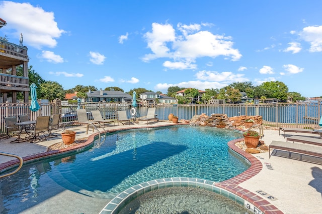 view of swimming pool with a patio area, a water view, and a community hot tub