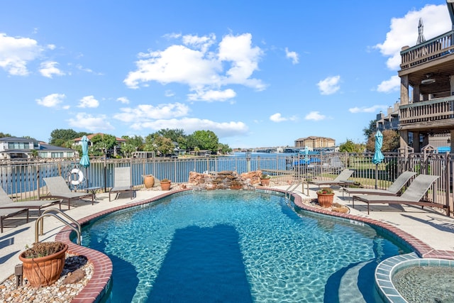 view of pool with a water view and a patio area