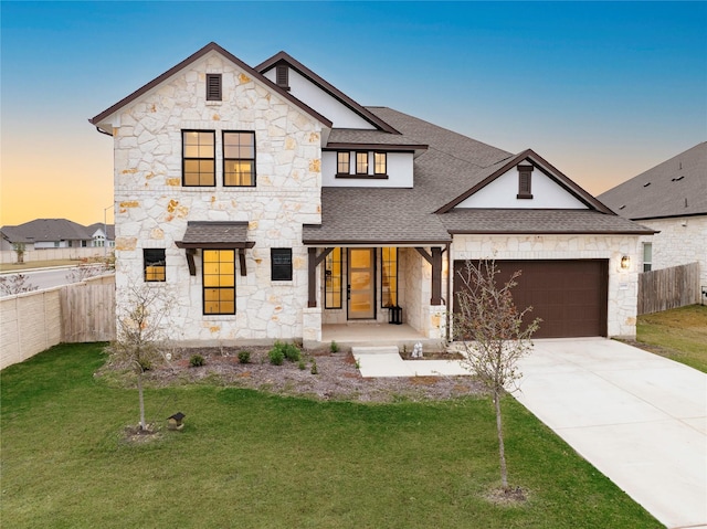 view of front of house with a lawn, covered porch, and a garage