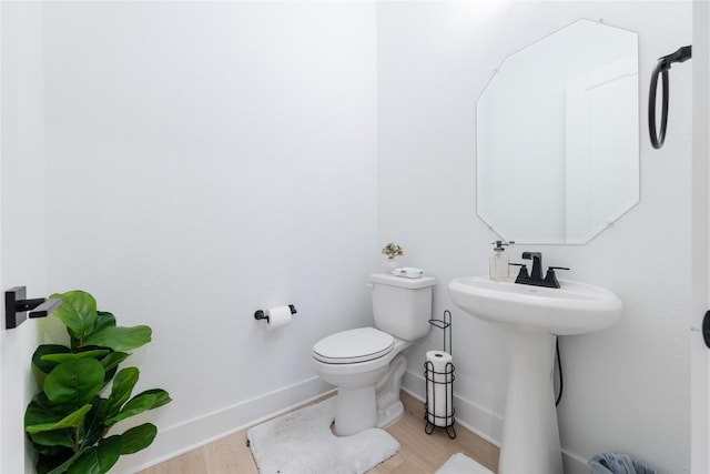 bathroom featuring hardwood / wood-style floors, toilet, and sink