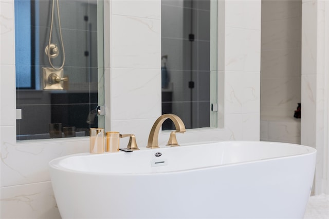 bathroom with a tub to relax in and sink