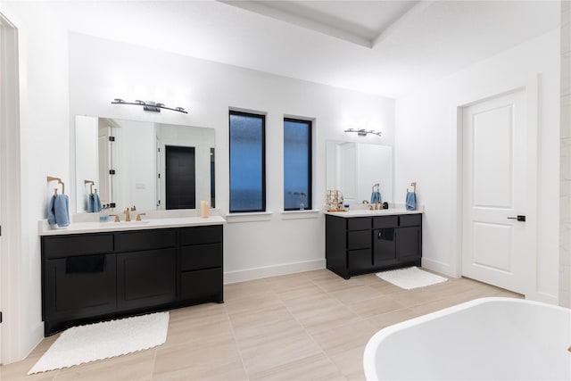 bathroom with tile patterned floors, a bathtub, and vanity