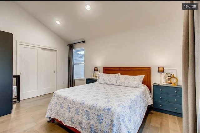 bedroom with a closet, vaulted ceiling, and light hardwood / wood-style floors