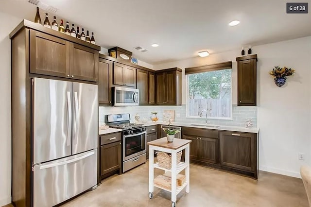 kitchen featuring appliances with stainless steel finishes, dark brown cabinets, and sink