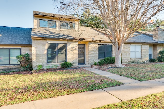 8233 Summer Side Dr Unit 172, Austin, TX 78759 - view of front of property with brick siding, a front yard, a shingled roof, and a chimney