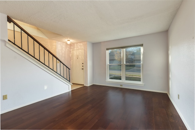 unfurnished living room with wood-type flooring and a textured ceiling