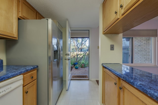 kitchen with stainless steel refrigerator with ice dispenser, white dishwasher, and dark stone counters