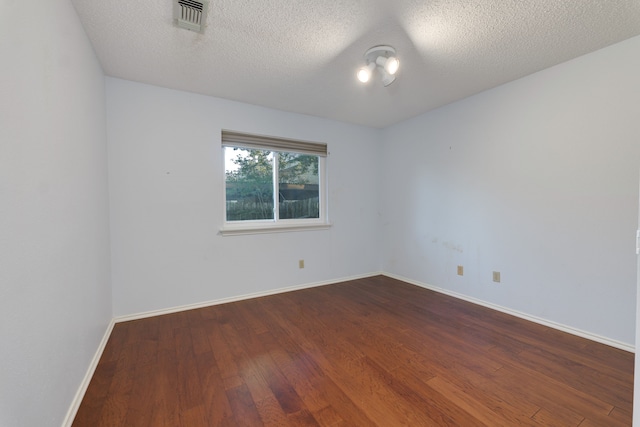 empty room featuring hardwood / wood-style floors and a textured ceiling