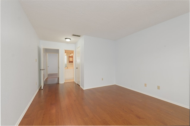 spare room with wood-type flooring and a textured ceiling