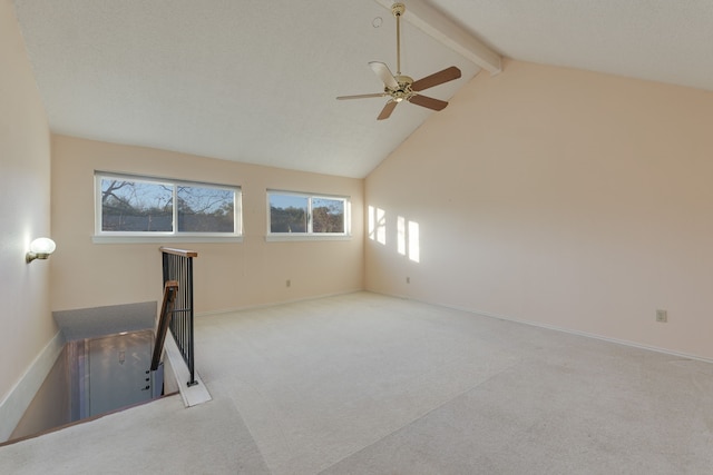 carpeted spare room featuring vaulted ceiling with beams and ceiling fan