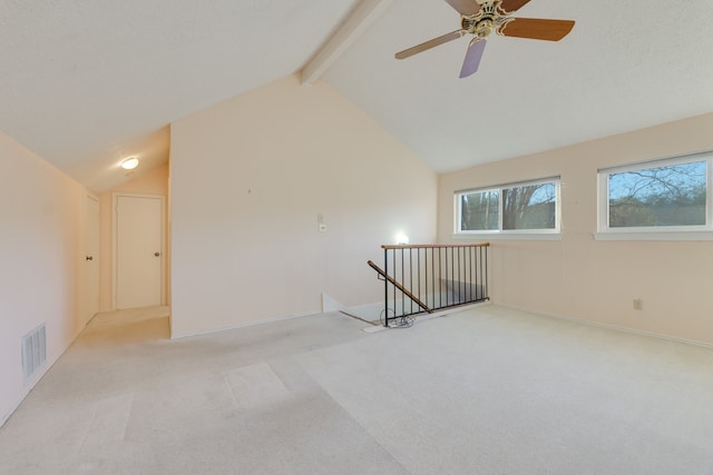 carpeted empty room with vaulted ceiling with beams and ceiling fan