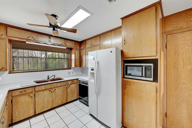 kitchen featuring ceiling fan, sink, white refrigerator with ice dispenser, light tile patterned floors, and dishwasher