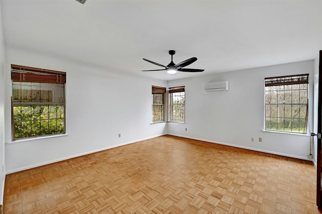 spare room with a wall mounted air conditioner, light parquet flooring, and ceiling fan