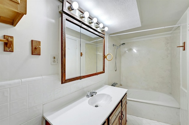 bathroom featuring tasteful backsplash, vanity, a textured ceiling,  shower combination, and tile walls