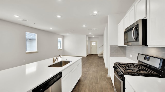 kitchen featuring tasteful backsplash, stainless steel appliances, sink, white cabinets, and dark hardwood / wood-style floors