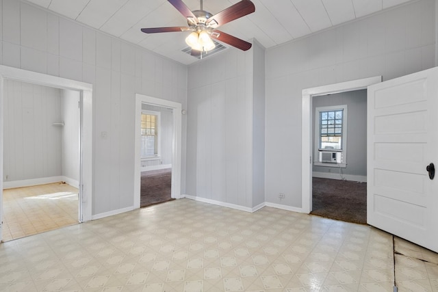 unfurnished bedroom with ceiling fan and wooden walls