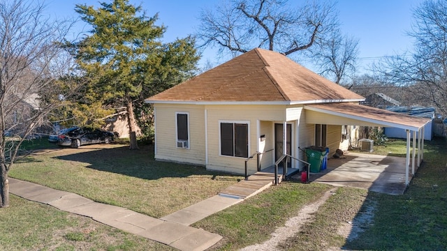 bungalow-style home featuring a carport, central AC, and a front lawn