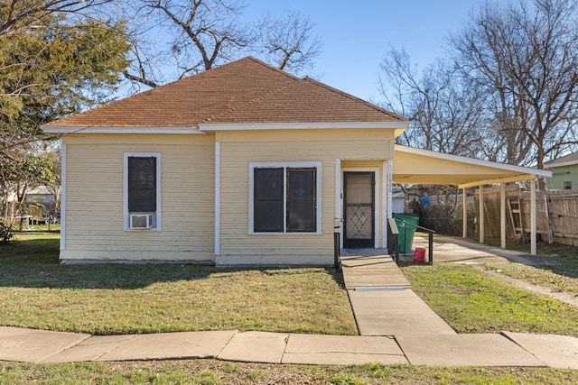 bungalow-style home with a front yard and a carport