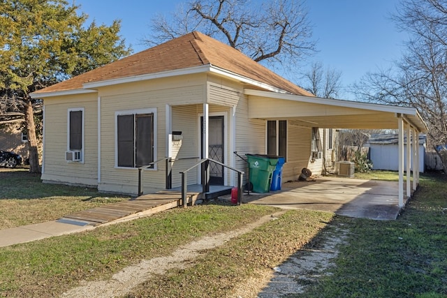 view of front of home with a carport, central AC unit, a front lawn, and cooling unit