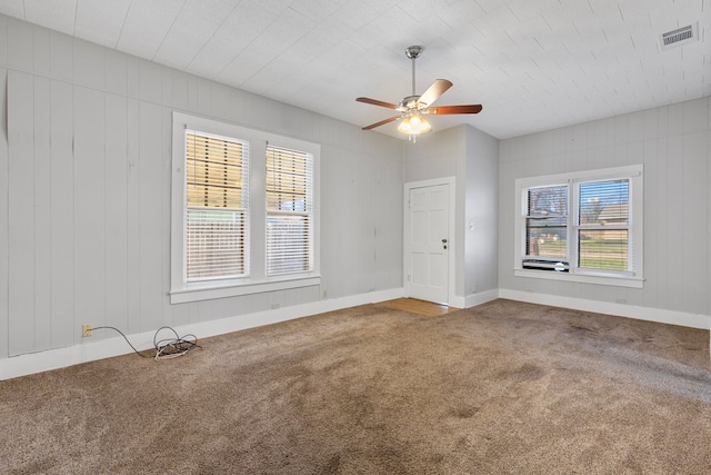 carpeted spare room featuring a wealth of natural light and ceiling fan