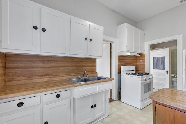 kitchen with white range with gas stovetop, tasteful backsplash, white cabinetry, and sink