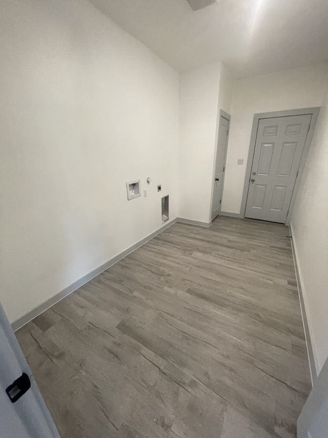 clothes washing area featuring washer hookup, light hardwood / wood-style flooring, and electric dryer hookup