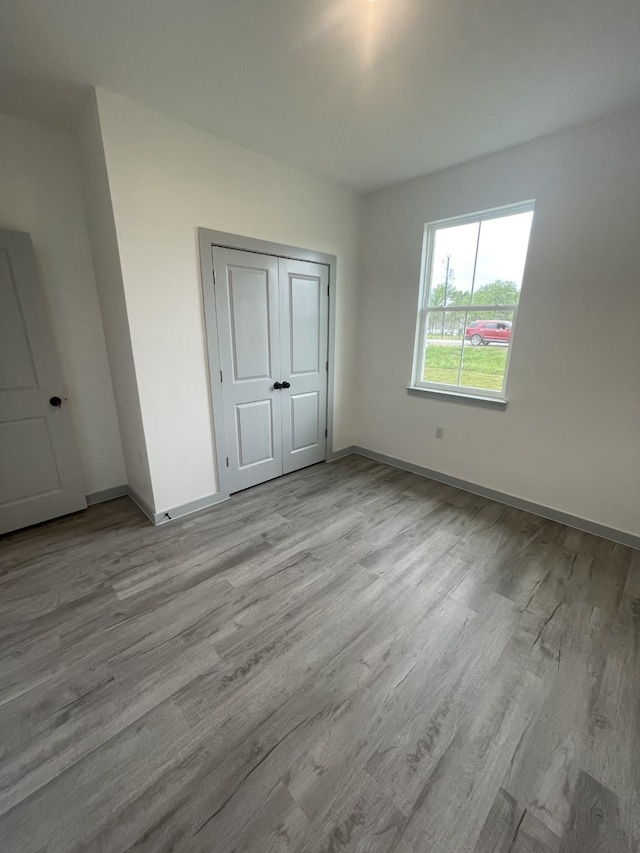 unfurnished bedroom featuring light hardwood / wood-style flooring and a closet