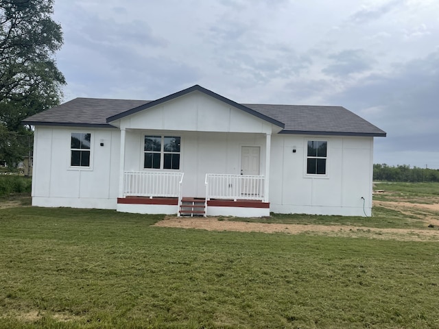 back of house featuring covered porch and a yard