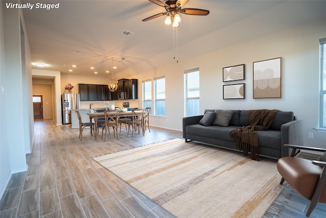 living room with ceiling fan and light hardwood / wood-style flooring