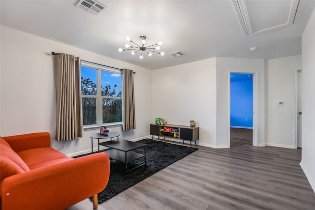 living room with hardwood / wood-style flooring and a notable chandelier