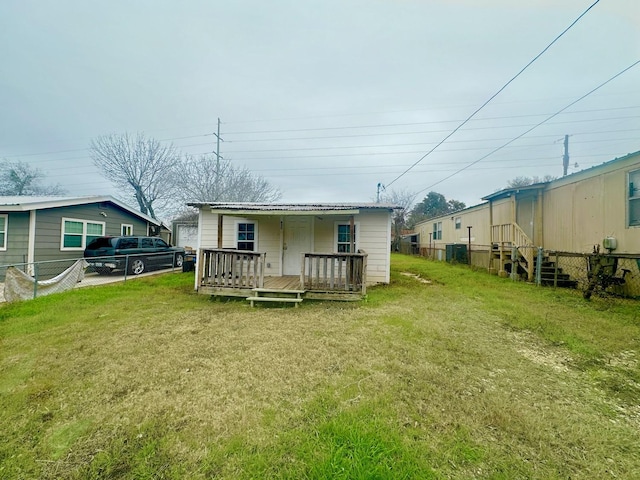 back of house featuring a wooden deck and a yard