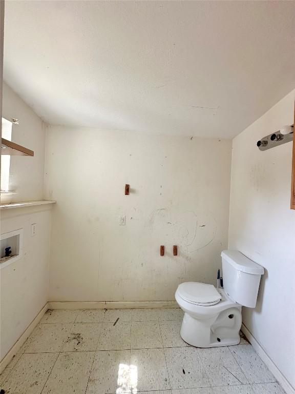 820 Chihuahua St, Lockhart, TX 78644 - bathroom featuring toilet, tile patterned floors, and baseboards