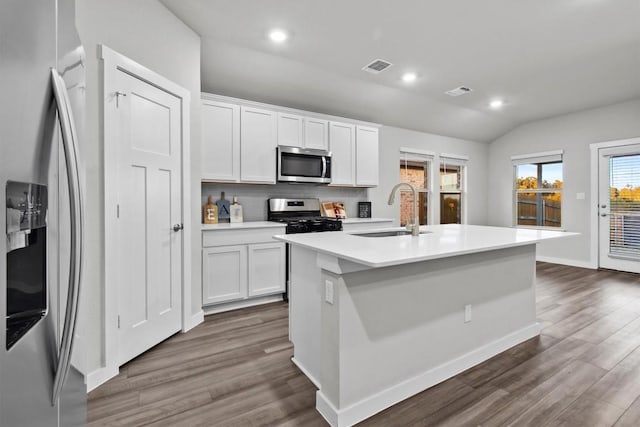 kitchen with sink, appliances with stainless steel finishes, white cabinetry, an island with sink, and dark hardwood / wood-style flooring