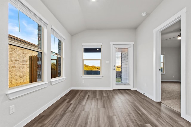 empty room featuring hardwood / wood-style floors, ceiling fan, a healthy amount of sunlight, and lofted ceiling