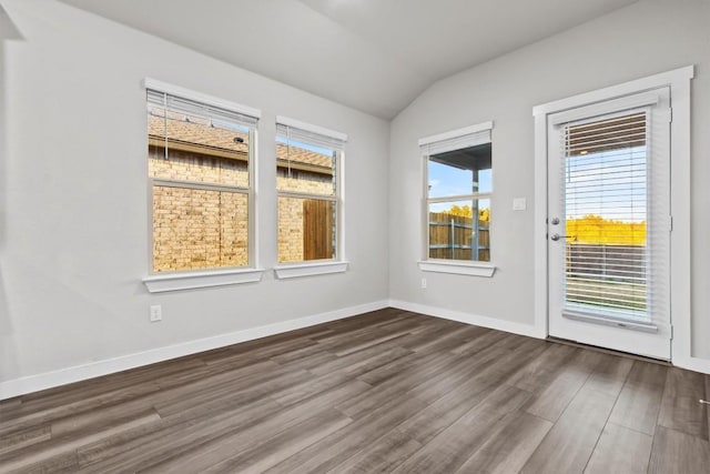 empty room with dark wood-type flooring and vaulted ceiling