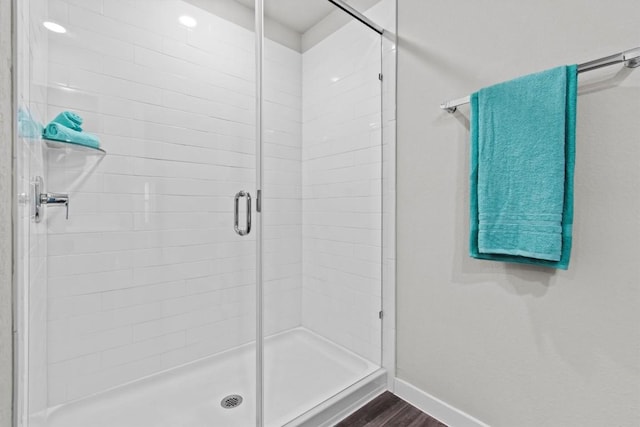 bathroom featuring hardwood / wood-style flooring and a shower with door