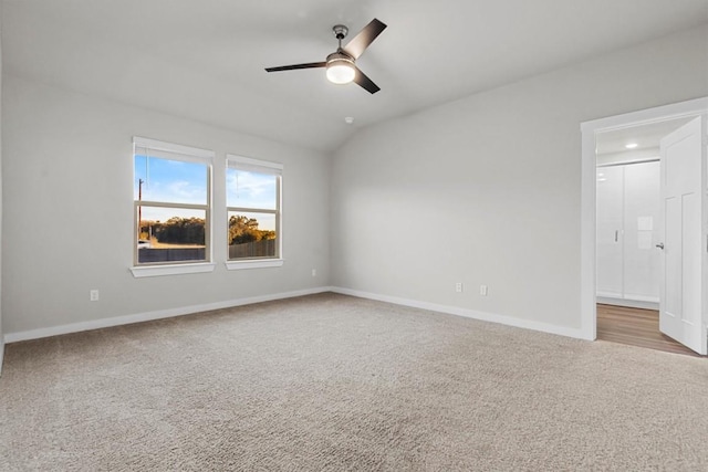 carpeted empty room with vaulted ceiling and ceiling fan