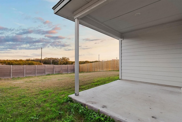 yard at dusk featuring a patio