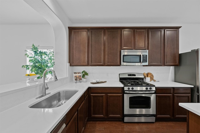 kitchen featuring dark hardwood / wood-style flooring, sink, dark brown cabinetry, and stainless steel appliances