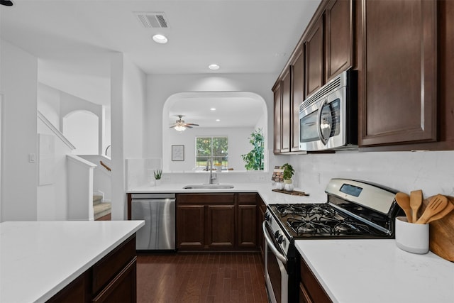 kitchen featuring ceiling fan, sink, dark hardwood / wood-style floors, dark brown cabinets, and appliances with stainless steel finishes