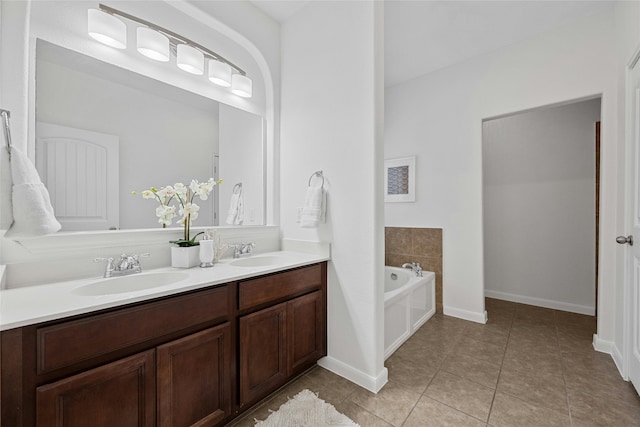 bathroom with tile patterned floors, a bathtub, and vanity