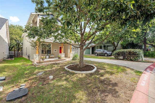 view of property hidden behind natural elements featuring a front yard, a garage, cooling unit, and covered porch