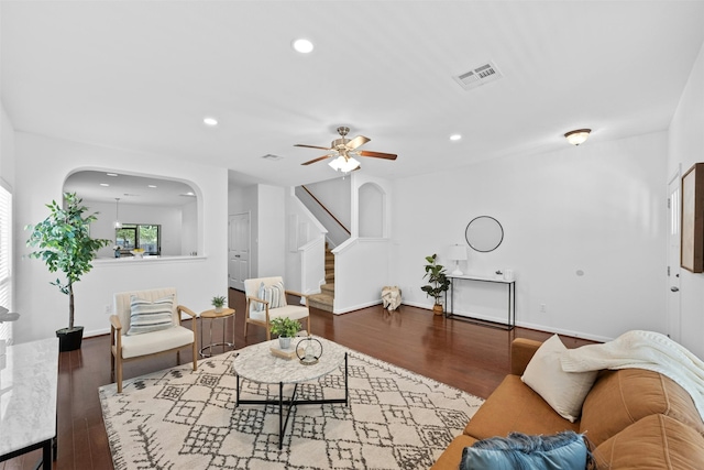 living room with ceiling fan and dark hardwood / wood-style flooring