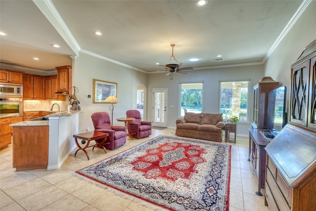 living room with sink, ceiling fan, crown molding, and light tile patterned flooring