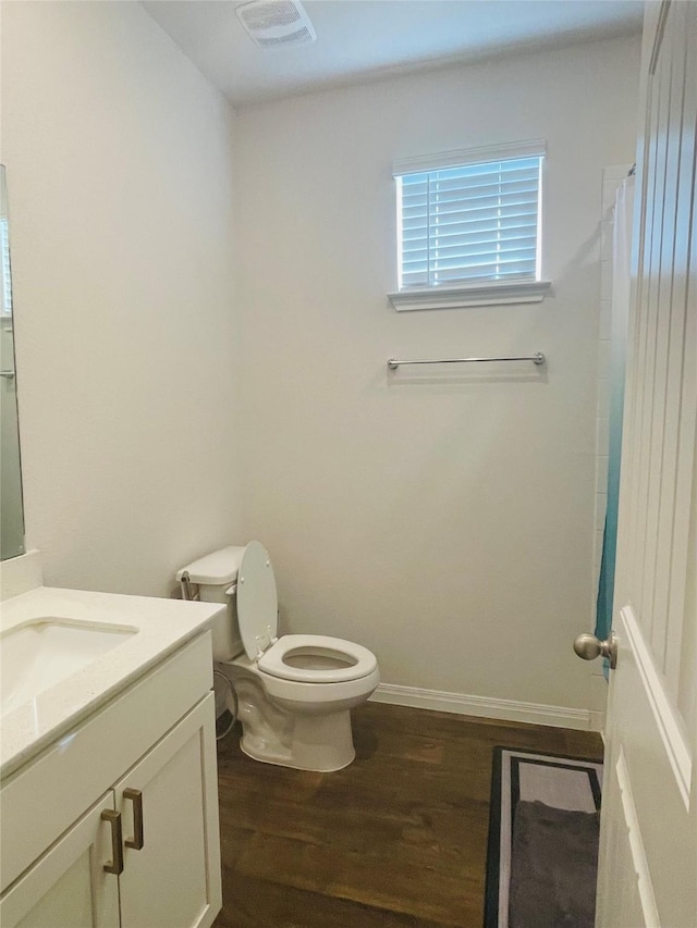 bathroom featuring hardwood / wood-style floors, vanity, toilet, and walk in shower