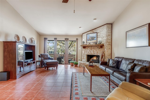 living room featuring tile patterned floors, ceiling fan, a stone fireplace, and lofted ceiling