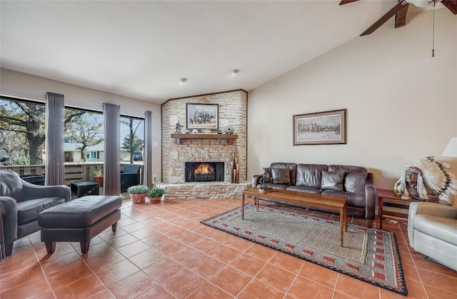 living room featuring lofted ceiling, a fireplace, a ceiling fan, and tile patterned floors
